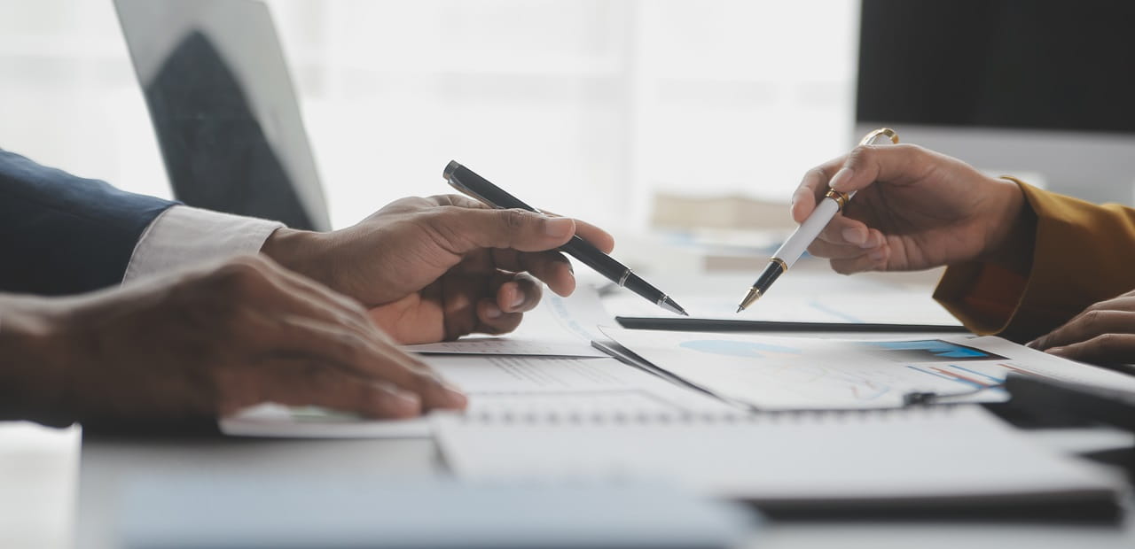 View of two sets of hands reviewing documents on a table.