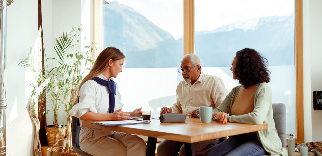 A couple meets with a financial advisor at a bright table to discuss charitable giving vehicles.