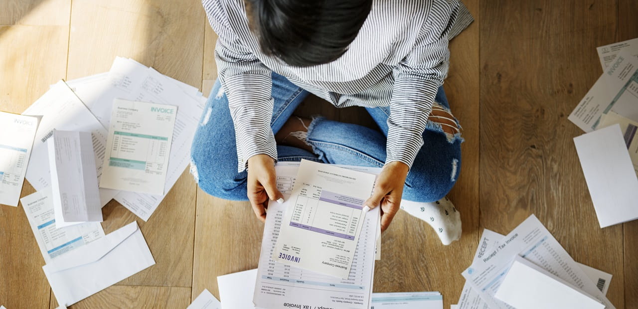 Bird's eye view of person sitting on floor reviewing documents.