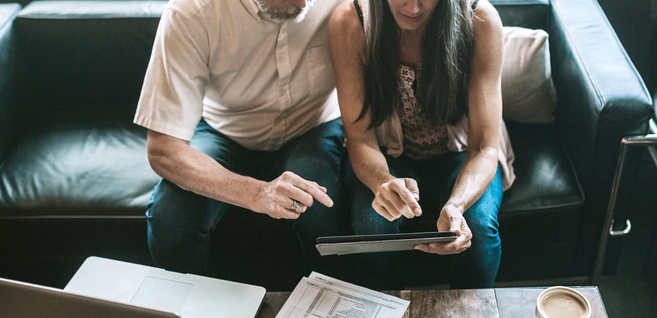 A mature adult couple has a discussion about their online tax process for their small business.