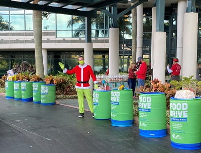 An associate dressed in holiday attire waves from RJFS food drive