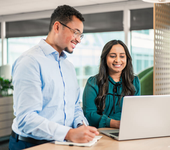 Young associates working together at laptop
