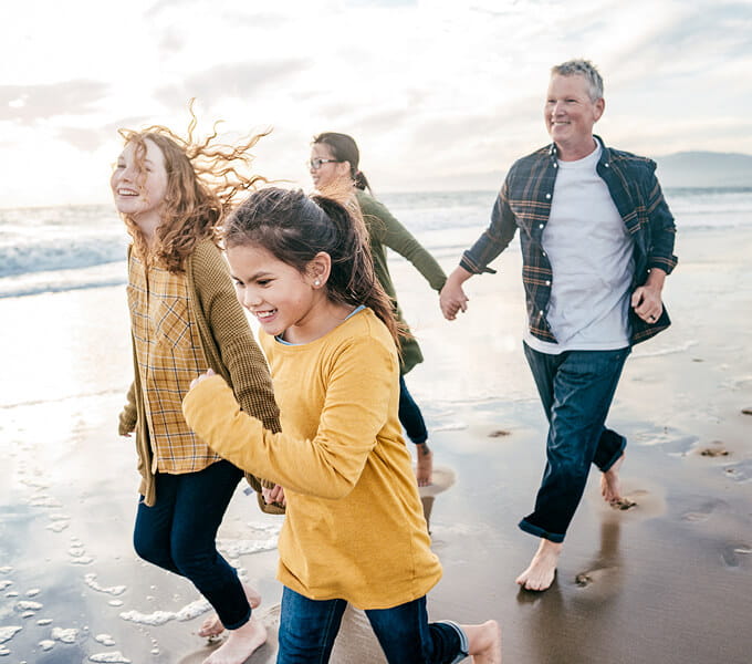 Family running together on the beach